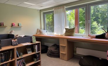 et rom med skrivebord og bokhylle
